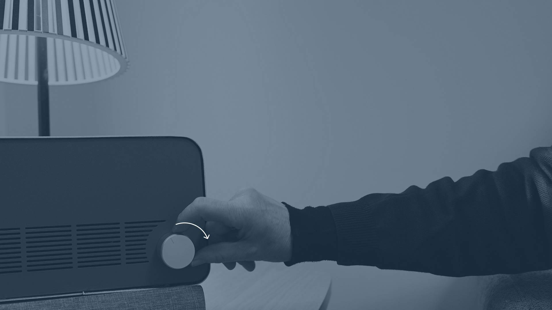 A hand turning the knob on the Ode speaker