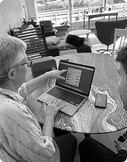 A woman and a colleague reviewing the Ode experience on a laptop