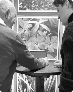 An older man demonstrating the Ode device with a team member