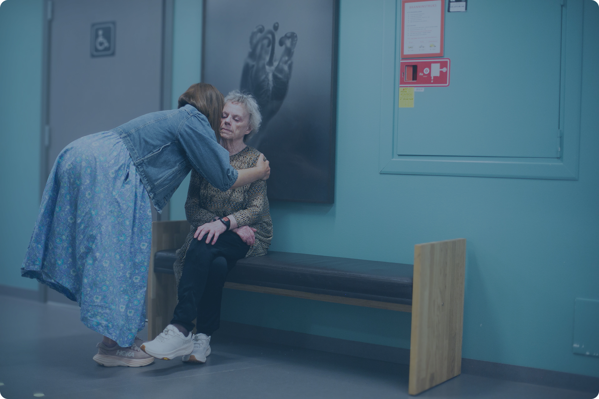 Marianne leans in to embrace her mother, seated on a bench